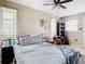 Cozy bedroom featuring tile floors, ceiling fan, and sunny windows at 23 Judith Ln, Orlando, FL 32811