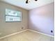 Bedroom with tile floors, a window and a light purple accent wall at 23 Judith Ln, Orlando, FL 32811