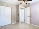 Neutral bedroom with tile floors, a double closet, ceiling fan and open doorway at 23 Judith Ln, Orlando, FL 32811