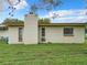 The exterior of the house showcasing its backyard, chimney, white brick walls, and simple window designs at 23 Judith Ln, Orlando, FL 32811