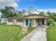 A single-story home with a well-maintained lawn, solar panels, and a walkway that leads to a vibrant blue front door at 23 Judith Ln, Orlando, FL 32811