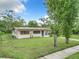 A single-story home with a well-maintained lawn, solar panels, and a walkway that leads to a vibrant blue front door at 23 Judith Ln, Orlando, FL 32811