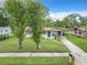 A single-story home with a well-maintained lawn, solar panels, and a walkway that leads to a vibrant blue front door at 23 Judith Ln, Orlando, FL 32811