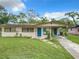 Charming single-story home featuring a well-manicured lawn and inviting blue front door at 23 Judith Ln, Orlando, FL 32811