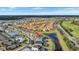 Aerial view of a residential area showcasing homes, a pond, and proximity to community amenities at 2383 Victoria Dr, Davenport, FL 33837