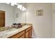 Bathroom featuring a double vanity with granite countertops and a large mirror with decorative lighting at 2383 Victoria Dr, Davenport, FL 33837