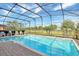 Screened pool features a brick deck with tranquil views of the golf course and blue skies at 2383 Victoria Dr, Davenport, FL 33837