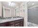 Well-lit bathroom features a double sink vanity with granite countertop and framed botanical prints at 2483 Dubai St, Kissimmee, FL 34747