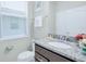 Bathroom featuring granite countertop, modern fixtures, window with blinds, and a toilet at 2483 Dubai St, Kissimmee, FL 34747