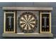 A dart board surrounded by score boards and metal decor on a gray brick wall at 2483 Dubai St, Kissimmee, FL 34747