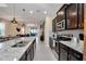 Modern kitchen featuring dark wood cabinets, stainless steel appliances, and an open view to the living area at 2483 Dubai St, Kissimmee, FL 34747