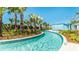 Serene lazy river with clear blue water, tropical plants, and lounge cabanas, perfect for relaxation and leisurely floats at 2483 Dubai St, Kissimmee, FL 34747