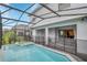 A screened-in pool area featuring a pool with an attached spa, perfect for relaxation and leisure at 2483 Dubai St, Kissimmee, FL 34747