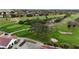 An aerial view of a golf course featuring mature trees, ponds, and manicured greens beside a clubhouse at 2625 Albion Ave, Orlando, FL 32833