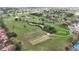 Aerial view of a lush green golf course featuring mature trees, ponds, and sand traps adjacent to homes at 2625 Albion Ave, Orlando, FL 32833