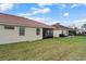 A well-maintained backyard with lush green grass, a screened in lanai, and a neutral-colored house exterior at 2625 Albion Ave, Orlando, FL 32833