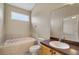 Bathroom featuring a soaking tub, a toilet, a sink, and neutral tile at 2625 Albion Ave, Orlando, FL 32833