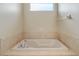 Bathroom featuring a tiled soaking tub and a window for natural light at 2625 Albion Ave, Orlando, FL 32833