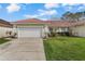 Well-manicured front yard with a two-car garage and red tiled roof at 2625 Albion Ave, Orlando, FL 32833