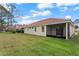 Rear exterior view of the home showing the tile roof, screened lanai, and well maintained lawn at 2625 Albion Ave, Orlando, FL 32833