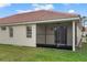 View of the screened lanai with ceiling fan overlooking the expansive green lawn at 2625 Albion Ave, Orlando, FL 32833