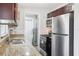 A kitchen features stainless steel appliances, granite countertops and dark wood cabinets at 2943 Truman Blvd, Sanford, FL 32771