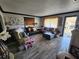 Bright living room with wood-look floors, a black sectional, and large windows at 3430 Kathy Ct, Lakeland, FL 33810