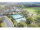 Aerial view of community amenities featuring tennis courts, a clubhouse, and a golf course at 3819 Breckinridge Ln, Clermont, FL 34711