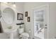 A well-lit bathroom featuring a pedestal sink, toilet, and a door to the patio with natural light at 3819 Breckinridge Ln, Clermont, FL 34711