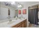 This bathroom features a double sink vanity with spacious counter and a shower with a gray shower curtain at 3819 Breckinridge Ln, Clermont, FL 34711