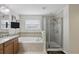 A bright bathroom featuring a soaking tub, a glass-enclosed shower, and a vanity with granite counters at 3819 Breckinridge Ln, Clermont, FL 34711