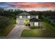 Two-story home featuring lush landscaping, paver driveway, and a welcoming facade at sunset at 3819 Breckinridge Ln, Clermont, FL 34711