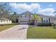 Charming two-story home with a paver driveway and well-manicured lawn, set against a blue sky at 3819 Breckinridge Ln, Clermont, FL 34711