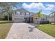 Beautifully landscaped two-story home featuring a paver driveway and lush green lawn at 3819 Breckinridge Ln, Clermont, FL 34711