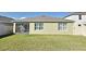 View of the backyard with a screened in porch, healthy lawn and neutral paint color at 3987 Silverstream Ter, Sanford, FL 32771