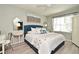 Airy bedroom features a plush bed with decorative pillows, accent mirrors, and natural light at 3987 Silverstream Ter, Sanford, FL 32771