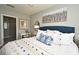 Comfortable bedroom featuring a blue upholstered headboard, white bedding, and a large decorative painting at 3987 Silverstream Ter, Sanford, FL 32771