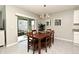 Bright dining room with a wood table set for six, sliding glass doors, and modern chandelier at 3987 Silverstream Ter, Sanford, FL 32771