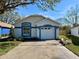 Charming one-story home featuring blue trim accents, a well-maintained yard, and an attached two-car garage at 425 Cadenza Dr, Orlando, FL 32807