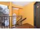 View of entrance to condo with yellow paint, black door, and stairway to beautiful lakeside view at 4536 Commander Dr # 1537, Orlando, FL 32822