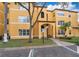 Close up of the yellow two-story apartment building with trees, grass, and handicap parking space at 4536 Commander Dr # 1537, Orlando, FL 32822