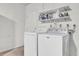 Functional laundry area with washer, dryer, and storage shelving at 4804 Laddie Ct, Orlando, FL 32821