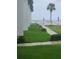 Lush backyard with manicured lawn, stone path leading to the ocean view and white beach fence at 4831 Saxon Dr # 1130, New Smyrna Beach, FL 32169