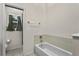 Full bathroom with a white tiled tub and a separate room for a toilet and window at 5149 Clarion Oaks Dr, Orlando, FL 32808