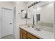 Bright bathroom featuring a full wall mirror and a large counter top with natural wood cabinets at 5149 Clarion Oaks Dr, Orlando, FL 32808