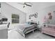 Bright bedroom featuring a ceiling fan, large window, hexagon shelving and a baby crib at 5149 Clarion Oaks Dr, Orlando, FL 32808