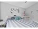 Comfortable bedroom with a queen size bed and a baby crib near a wall with decorations at 5149 Clarion Oaks Dr, Orlando, FL 32808