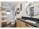 Bathroom featuring a modern sink, black countertops, shower with white subway tiles, and wooden floors at 5335 Canoe Creek Rd, St Cloud, FL 34772