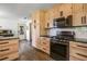 Bright kitchen featuring wooden cabinetry, stainless steel appliances, and hardwood floors at 5335 Canoe Creek Rd, St Cloud, FL 34772