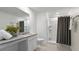Bathroom featuring granite countertop vanity, tiled floors, and walk-in shower with dark curtain at 545 Jerry Ln, Haines City, FL 33844